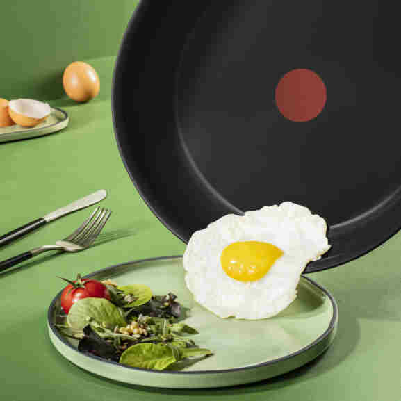 Tefal Renew Black koekenpan 24 cm met keramische coating in actie tijdens het bakken, toont uitstekende
